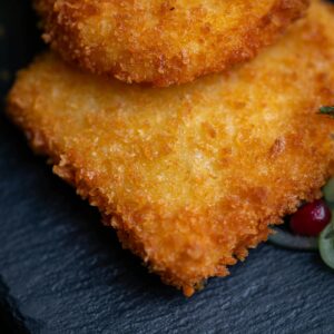 Close-up of golden crispy breaded schnitzel on a slate plate, mouthwatering and delicious.